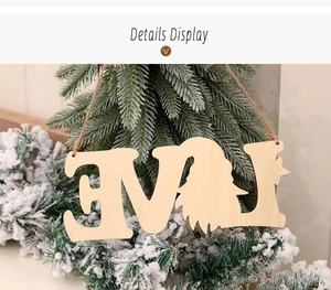Détail d'un panneau LOVE en bois avec gnome suspendu sur un sapin de Noël enneigé