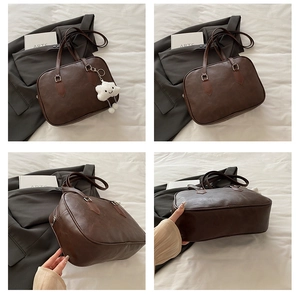 Detail view of deep brown Boston bag with smooth PU leather and silver metal rings