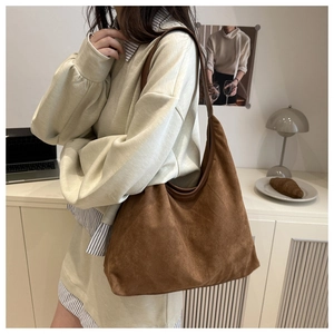 Detailed view of the large brown suede tote bag in a casual stylish shoulder carry