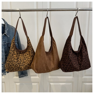 Hanging display of three large hobo bags in leopard print and brown matte suede textures
