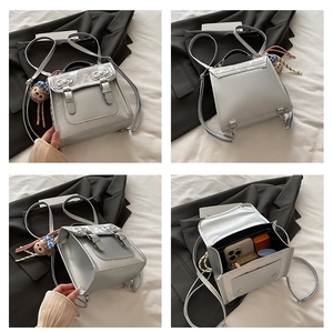 Detail view of silver metallic mini backpack with bow, adjustable straps and plush charm