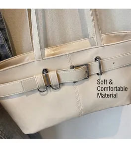 Gros plan du sac cabas en cuir blanc crème avec boucle décorative et anneau en métal argenté