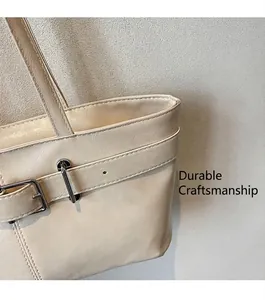 Détail du sac cabas en cuir texturé beige avec boucle argentée et coutures soignées