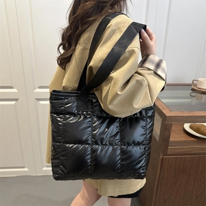 Chic black quilted tote bag with glossy finish and large capacity for casual commuting