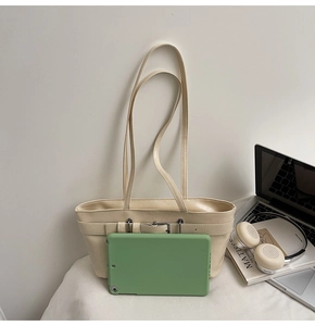 Détail du sac à bandoulière blanc cassé avec boucle à côté d'une tablette pour la taille
