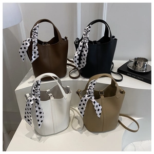 Minimalist litchi grain bucket bags in brown, black, and white with polka dot scarves