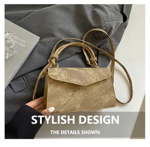 Detail of vintage brown textured crossbody bag with knotted handle and shoulder strap