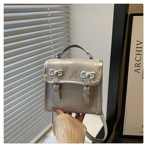 Detail of silver metallic handbag with bow buckles and elegant ruffled edges