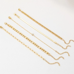 Ensemble de cinq bracelets dorés avec maille serpent, gourmette et détails zircon