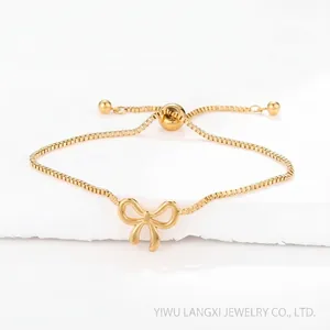 Detailed macro view of a gold bow pendant on a box chain with adjustable slider bead