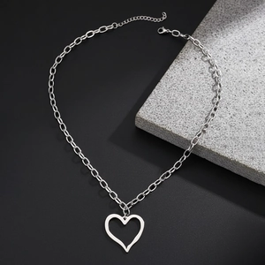 Collier minimaliste avec pendentif cœur irrégulier et chaîne trombone sur fond noir