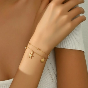 Close-up of double-layer stainless steel bracelet with starfish, shell and zircon charms