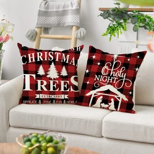 Détail de housses de coussin de Noël en tartan rouge et noir avec motifs festifs