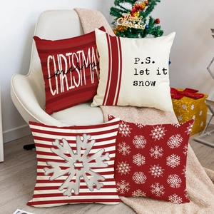Set of 4 Christmas pillow covers with snowflake and let it snow text on a white chair