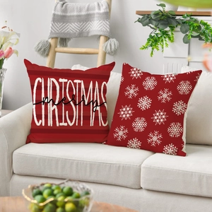 Detail view of merry Christmas lettering and white snowflake patterns on red cushion covers