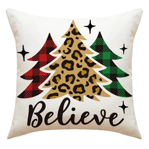 Close-up of linen Christmas pillowcase featuring three patterned trees and Believe text