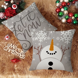 Detalle de fundas de cojín navideñas de lino gris con estampados de Let it Snow y muñeco de nieve
