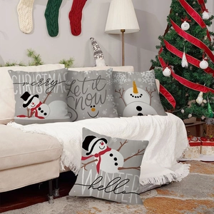 Vista detallada de cuatro fundas de cojín de Navidad con muñecos de nieve en sofá