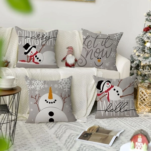 Detalle de cuatro fundas de cojín de lino festivas con motivos de muñeco de nieve