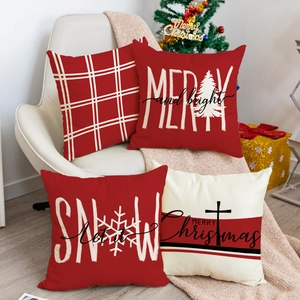 Dettaglio di quattro federe natalizie con scritte festive e texture in lino rosso e bianco