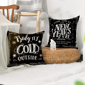Détail de housses de coussin de Noël avec texte Baby it's Cold Outside et flocons de neige