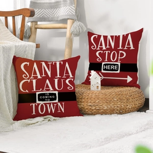 Detailed view of red Christmas pillows with Santa belt design and festive holiday quotes