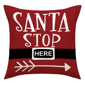 Detail of red Santa Stop Here Christmas pillow cover with belt pattern and art lettering