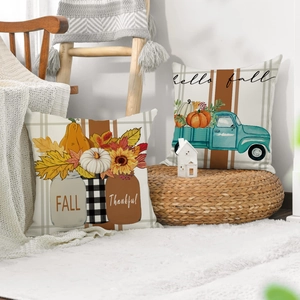 Detail der Leinenkissenbezüge mit Herbstkürbissen und Oldtimer auf einer weißen Strickdecke