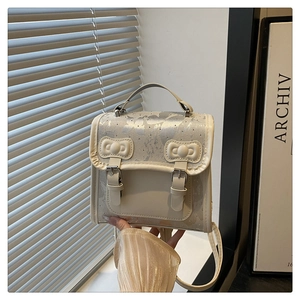 Detail of cream backpack featuring grey butterfly print and relief bow decorations