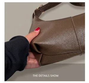 Close-up of brown litchi pattern leather texture and precise stitching on the shoulder bag