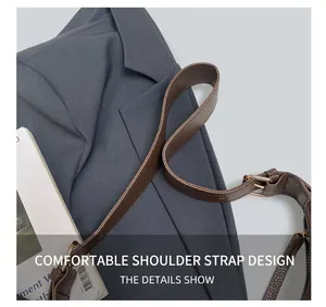 Close-up of brown lychee grain leather strap with gold buckle on a stylish shoulder bag