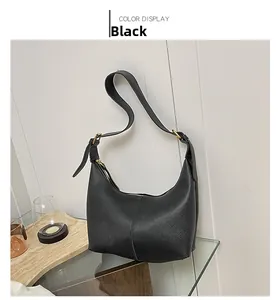 Detail view of black pebble texture leather hobo bag with gold zipper and adjustable strap