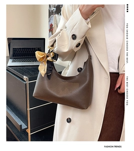 Detailed texture of dark brown pebbled leather hobo bag with floral scarf on strap