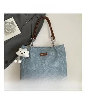 Detail of floral jacquard tote bag with leather handles and cloud charm ornament