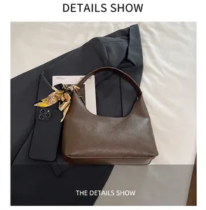 Detail of brown lychee grain leather hobo bag with floral silk scarf and smartphone