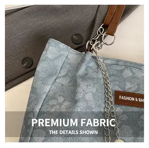 Detail of light blue floral jacquard tote with leather straps and silver metal chains