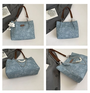 Detail of floral canvas tote bag featuring pearl chain and plush cloud charm accessory