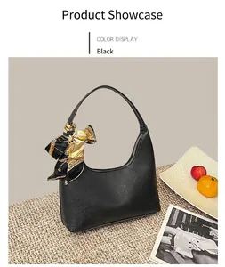 Detailed view of black litchi pattern leather shoulder bag with decorative silk scarf