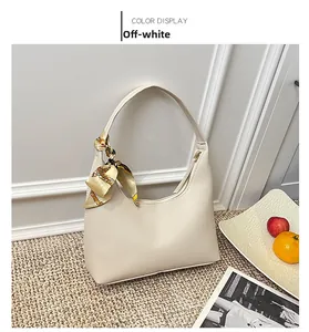 Detail of off-white crescent shoulder bag with lychee texture and silk scarf handle