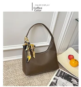 Detail of coffee brown hobo bag with pebble leather texture and decorative scarf