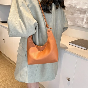 Brown orange crescent hobo shoulder bag with lychee texture leather on female model