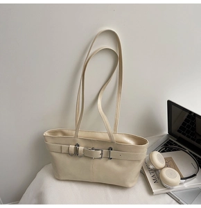 Détail du sac bandoulière crème minimaliste avec boucle argentée et sangle décorative