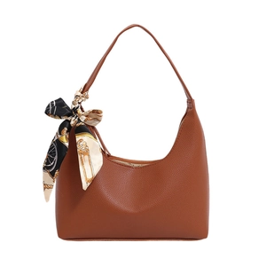 Brown lychee leather crescent shoulder bag with vintage silk scarf on white background