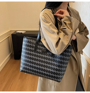Detailed view of large tote bag with geometric print and golden protective metal feet