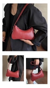 Detail of red lychee pattern leather hobo bag with smooth zipper and shoulder strap