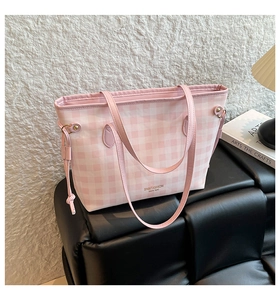 Detailed view of pink plaid tote bag texture and brand logo with stylish drawstring detail