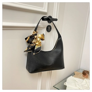 Detail of black crescent hobo bag with lychee texture leather and a floral silk scarf