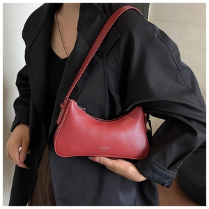 Close-up of red lychee grain leather underarm bag with silver logo detail