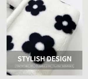 Close-up of white plush shoulder bag featuring bold black floral patterns and soft texture