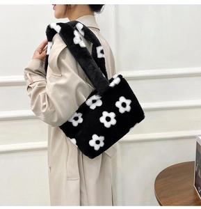 Detail of plush faux fur shoulder bag featuring large white floral pattern on black surface